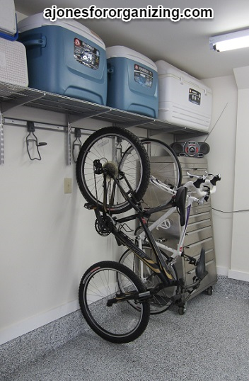 https://www.ajonesfororganizing.com/wp-content/uploads/2021/04/A-Jones-For-Organizing-garage-bikes-stored-vertically-on-Elfa-bike-hooks.png?x67194